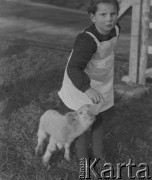 1942-1944, Deiswil, Szwajcaria.
Dziewczynka karmi butelką małe jagnię.
Fot. Jerzy Konrad Maciejewski, zbiory Ośrodka KARTA