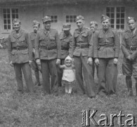 1940-1941, Münchenbuchsee, Szwajcaria.
Żołnierze z 2. Dywizji Strzelców Pieszych pozują do wspólnego zdjęcia. Dwóch z nich trzyma za ręce małe dziecko.
Fot. Jerzy Konrad Maciejewski, zbiory Ośrodka KARTA