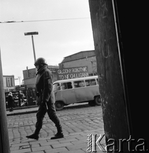 14-22.12.1970, Szczecin, Polska.
Wydarzenia grudniowe - ul. Tomasza Nocznickiego, ZOMO-owiec obserwujący teren Stoczni Szczecińskiej im. Adolfa Warskiego. W głębi tablica z napisem: 