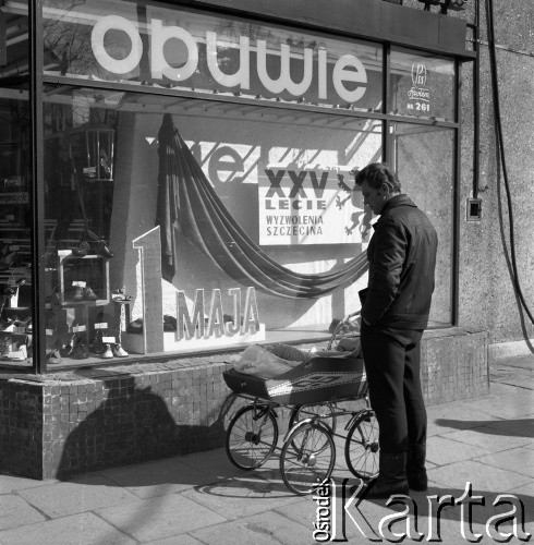 1970, Szczecin, Polska.
Ojciec z dzieckiem przed witryną sklepową udekorowaną na Święto 1 Maja.
Fot. Maciej Jasiecki, zbiory Ośrodka KARTA