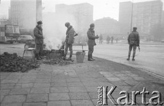 Po 13.12.1981, Warszawa, Polska.
Początek stanu wojennego, milicjanci przy koksowniku przy ul. Marszałkowskiej.
Fot. Małgorzata Niezabitowska i Tomasz Tomaszewski, zbiory Ośrodka KARTA