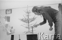 24.12.1981, Warszawa, Polska.
Małgorzata Niezabitowska zapala świecę przy choince przystrojonej kartką z napisem 