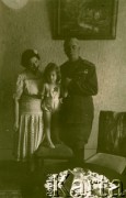 Lata 40., Rumunia.
Mężczyzna w wojskowym mundurze trzyma za rękę dziewczynkę stojącą na krześle, z lewej stoi kobieta w letniej sukience.
Fot. NN, zbiory Ośrodka KARTA
