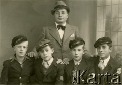 04.10.1939, Ploesti, Rumunia.
Czterej chłopcy w gimnazjalnych mundurkach i czapkach, za nimi stoi mężczyzna w kapeluszu i garniturze; podpis na odwrocie: