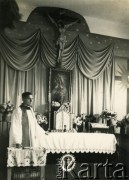 Lata 40., Rumunia
Ksiądz stojący przy ołtarzu, nad którym wisi obraz Matki Boskiej i krzyż z figurą Jezusa Chrystusa.
Fot. NN, zbiory Ośrodka KARTA