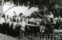 Lata 40., Rumunia.
Polscy uchodźcy w Rumunii podczas II wojny światowej - grupa osób siedzi przy trzech zastawionych stołach, z prawej stoi Stanisław Wisłocki.
Fot. NN, zbiory Ośrodka KARTA.