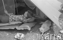 Sierpień 1982, Warszawa, Polska.
Chłopiec odpoczywa na materacu, obok śpi pies.
Fot. Maciej Czarnocki, zbiory Ośrodka KARTA