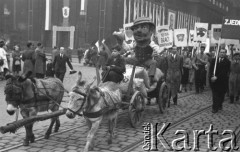 1.05.1954, Stalinogród (Katowice), Polska.
Pochód pierwszomajowy, chłopiec na wozie zaprzężonym w osiołki, z tyłu manifestanci z hasłem: 