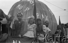 1.05.1954, Katowice, Polska.
Pochód pierwszomajowy, dziewczynki na platformie z kulą ziemską ozdobioną napisami 