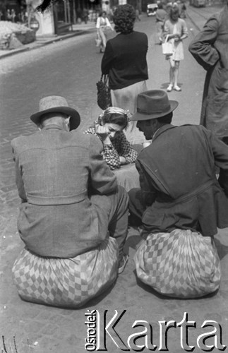 1957, Budapeszt, Węgry.
Fragment ulicy, dwaj mężczyźni siedzą na workach leżących na ulicy.
Fot. Kazimierz Seko, zbiory Ośrodka KARTA
