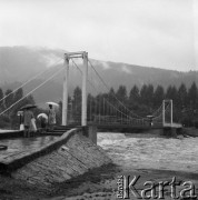 Sierpień 1972, brak miejsca, Beskidy, Polska.
Powódź w Beskidach, ludzie z parasolkami oglądający z mostu wezbraną rzekę, w tle góry.
Fot. Kazimierz Seko, zbiory Ośrodka KARTA