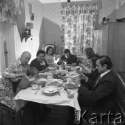 Lata70-te, Śląsk, Polska.
Wielopokoleniowa rodzina górnicza siedząca przy stole podczas obiadu, w kącie pokoju stoi telewizor.
Fot. Kazimierz Seko, zbiory Ośrodka KARTA
