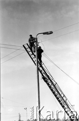 Październik 1962, Warszawa, Polska.
Dwaj elektrycy pracujący na drabinie.
Fot. Jarosław Tarań, zbiory Ośrodka KARTA [62-86]
