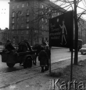 23.11.1962, Warszawa, Polska.
Dwie osoby jadące konnym wózkiem po ulicy. Obok tablica z napisem: 