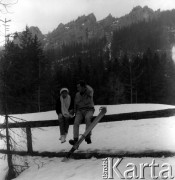 Kwiecień 1962, Zakopane, Polska.
Dwoje turystów siedzących na żerdzi na tle gór.
Fot. Jarosław Tarań, zbiory Ośrodka KARTA [62-08]

