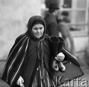 Pażdziernik 1970, Opoczno, Polska
 Dzień targowy, kobieta z butami.
 Fot. Jarosław Tarań, zbiory Ośrodka KARTA [70-117]
   
