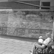 20.05.1975, Polska
Młoda kobieta z dzieckiem siedząca na ławce, w tle ściana z płaskorzeźbą przedstawiającą rowerzystów.
Fot. Jarosław Tarań, zbiory Ośrodka KARTA [75-55]
 

