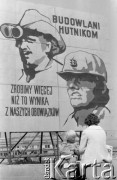 18.05.1976, Katowice, Polska
Budowa Huty Katowice, kobieta z dzieckiem koło tablicy z hasłem: 