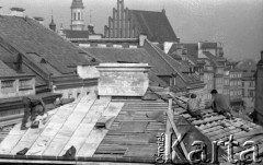 Październik 1977, Warszawa, Polska.
Dekarze pracujący na dachu kamienicy, w tle Starówka.
Fot. Jarosław Tarań, zbiory Ośrodka KARTA [77-172]
