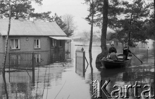 Marzec 1979, Rybienko, woj. Ostrołęka, Polska.
Powódź - zatopione domy mieszkalne oraz drzewa. Powodzianie w łódce.
Fot. Jarosław Tarań, zbiory Ośrodka KARTA [79-29] 
