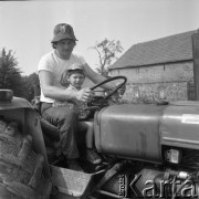 Czerwiec 1981, Zagozd, pow. Drawsko Pomorskie, Polska
Gospodarstwo rodziny Grzybickich, mężczyzna z chłopcem na traktorze, z prawej na masce naklejka 