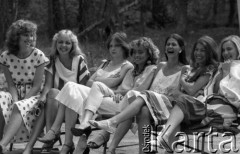 Maj 1985, Zalesie Górne, Polska
Wybory Miss Polonia, zgrupowanie przedfinałowe, roześmiane dziewczyny siedzące na ławce.
Fot. Jarosław Tarań, zbiory Ośrodka KARTA [85-9] 
