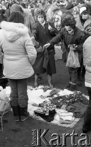 22.11.1986, Warszawa - Rembertów, Polska.
Bazar z ubraniami w Rembertowie, kobiety oglądające sweter.
Fot. Jarosław Tarań, zbiory Ośrodka KARTA, [86-43] 
