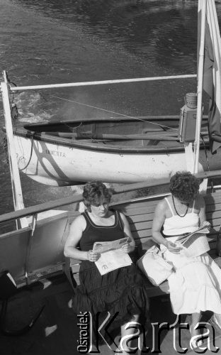 Sierpień 1988, brak, miejsca, Polska
Rejs statkiem wycieczkowym, kobiety czytające gazety, z tyłu łódź ratunkowa.
Fot. Jarosław Tarań, zbiory Ośrodka KARTA [88-19] 
