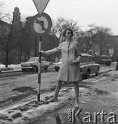 28.02.1968, Warszawa, Polska.
Pokaz mody - modelka prezentuje płaszcz  opierając się o drogowskaz, w tle samochody marki 