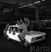 Wrzesień 1968,  Warszawa - Żerań, Polska.
Pierwszy Polski Fiat 125 p. opuszcza taśmę montażową w Fabryce Samochodów Osobowych - pracownicy pozują do zdjęcia w nowo wyprodukowanym samochodzie  Napis na plakacie: 