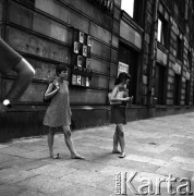 19.06.1968, Warszawa, Polska.
Upalne lato w centrum miasta - młode dziewczyny spacerujące boso po ulicy. Za kobietami widoczny jest szyld zakładu fotograficznego: 
