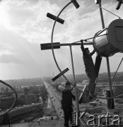1968, Warszawa, Polska.
Robotnicy montujący zegar na dachu wieżowca przy Rondzie Waszyngtona, w tle Stadion X-o Lecia.
Fot. Jarosław Tarań, zbiory Ośrodka KARTA