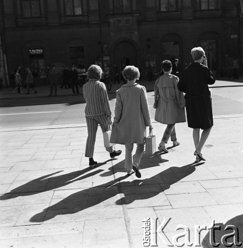 1968, Kraków, Polska.
Cztery kobiety spacerujące po Rynku Głównym w Krakowie, w tle zabytkowe kamienice i tłum ludzi.
Fot. Jarosław Tarań, zbiory Ośrodka KARTA