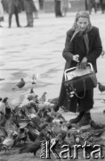 1965, Kraków, Polska.
Kobieta ksmi gołębie na Rynku krakowskim.
Fot. Jerzy Mąkowski, zbiory Fundacji Ośrodka KARTA