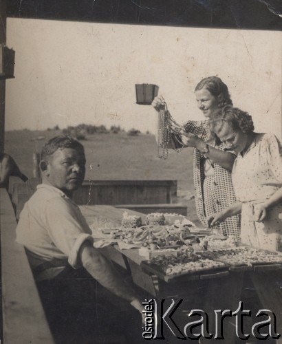Przed 1939, Polska.
Młode kobiety przy straganie z ozdobami.
Fot. NN, zbiory Ośrodka KARTA, udostępniła Wanda Biłat
 
