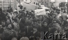 13.12.1981, Paryż, Francja.
Prawdopodobnie popołudniowa manifestacja w dniu ogłoszenia w Polsce stanu wojennego. Zgromadzeni stoją przy zbiegu rue de Talleyrand i placu Inwalidów. Policjanci zastawili wejście do ambasady. Na kartce napis: 