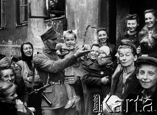 09.194, Warszawa, Polska.
Sierżant LWP z dziewczynką na ręku, w otoczeniu kobiet i dzieci na ul. Brzeskiej na Pradze w Warszawie.
Fot. Józef Rybicki, Stanisława Rybicka, zbiory Fundacji Ośrodka KARTA