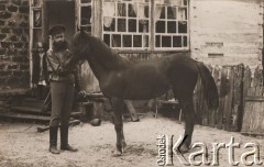 Lato 1917, Achtyrka, Charkowska gubernia, Ukraina, Rosja.
Mężczyzna w rosyjskim mundurze z koniem na podwórku przed domem.
Fot. NN, zbiory Ośrodka KARTA, udostepniła Janina Bojarska
   
