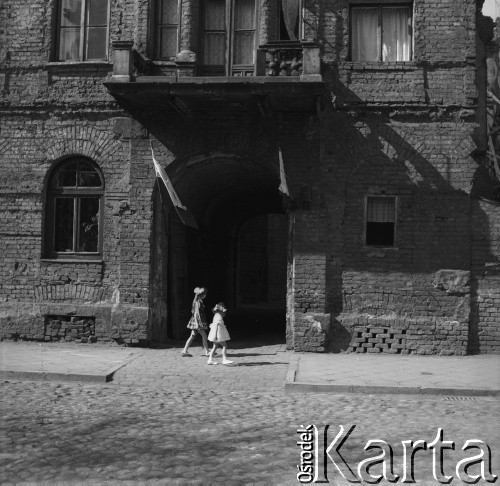 Ok. 1960, Warszawa, Polska.
Dziewczynki przed bramą kamienicy. Fotografia wykonana na zlecenie miesięcznika 