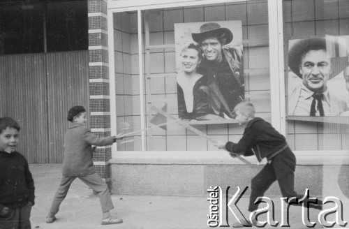 1960, Warszawa, Polska.
Chłopcy bawiący się przed kinem Skarpa. W tle fotosy z filmu 
