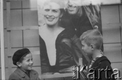 1960, Warszawa, Polska.
Chłopcy bawiący się przed kinem Skarpa. W tle fotos z filmu 