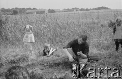 1961, Polska.
Miejscowe dzieci przyglądają się turyście leżącemu na trawie.
Fot. Bogdan Łopieński, zbiory Ośrodka KARTA