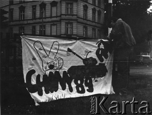 8.06.1989, Gdańsk, Polska.
Mężczyzna wieszający transparent Federacji Młodzieży Walczącej dotyczący masakry na Placu Niebiańskiego Spokoju w Pekinie w dniu 4 czerwca 1989 roku.
Fot. NN, Archiwum Federacji Młodzieży Walczącej, zbiory Ośrodka KARTA