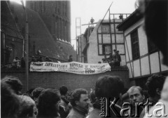 Koniec lat 80., Gdańsk, Polska.
Wiec na terenie kościoła św. Brygidy. Na murze przedstawiciele Federacji Młodzieży Walczącej z transparentem: 