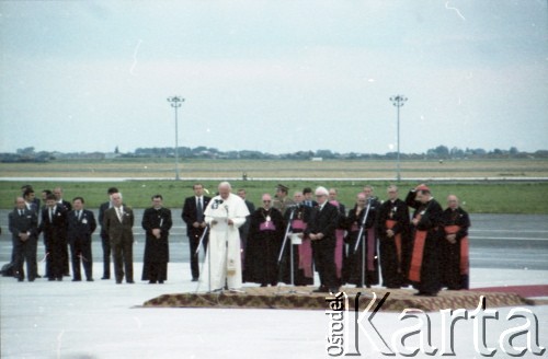 16.06.1983, Warszawa, Polska.
Druga pielgrzymka papieża Jana Pawła II do Polski w dniach 16-23 czerwca 1983 roku. Ceremonia powitalna na lotnisku Okęcie; przemawia Ojciec Święty, obok przewodniczący Rady Państwa Henryk Jabłoński i prymas Polski kardynał Józef Glemp. Z tyłu z prawej sekretarz stanu Stolicy Apostolskiej arcybiskup Agostino Casaroli i arcybiskup metropolita krakowski kardynał Franciszek Macharski.
Fot. Edward Grochowicz, zbiory Ośrodka KARTA