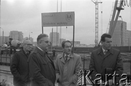 Lata 80., Warszawa, Polska.
Przedstawiciele władz na terenie budowy I linii metra. Od prawej: Jerzy Majewski – pełnomocnik rządu ds. budowy metra,  Tadeusz Romanowski - wicedyrektor Metroprojektu i generalny projektant I linii metra w Warszawie, NN, Józef Alfred Zajączkowski - zastępca dyrektora Generalnej Dyrekcji Budowy Metra.
Fot. Edward Grochowicz, zbiory Ośrodka KARTA