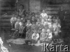 20.05.1941, Kazimirowiczi (?), ZSRR.
Wychowankowie Domu Dziecka ze swoimi opiekunkami pozują do fotografii siedząc przed ścianą budynku.
Fot. NN, zbiory Ośrodka KARTA, udostępniła Anastazja Michałczak