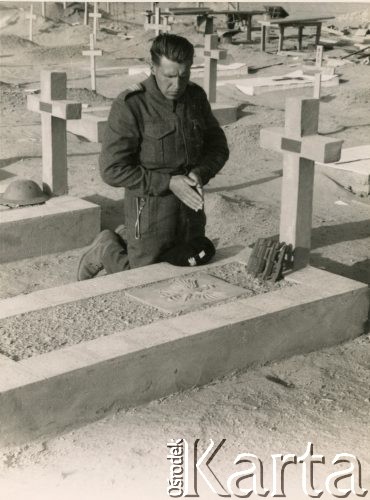 Po 1941, Tobruk, Libia.
Polski żołnierz modli się przy grobie na cmentarzu wojennym.
Fot. NN, udostępnili Zofia i Julian Michalski, zbiory Ośrodka KARTA