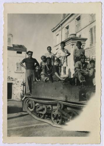 1945-1946, Włochy.
Włoskie dzieci pozują do zdjęcia z żołnierzami 5 Kresowej Dywizji Piechoty 2 Korpusu Polskiego PSZ na Zachodzie, siedząc na lekkiej tankietce. 
Fot. NN, kolekcja Marcina Rudzińskiego, zbiory Ośrodka KARTA