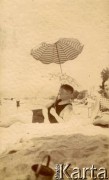 1925-1927, Francja.
Mężczyzna odpoczywa na plaży pod parasolem.
Fot. NN, kolekcja Larysy Zajączkowskiej-Mitznerowej, zbiory Ośrodka KARTA
